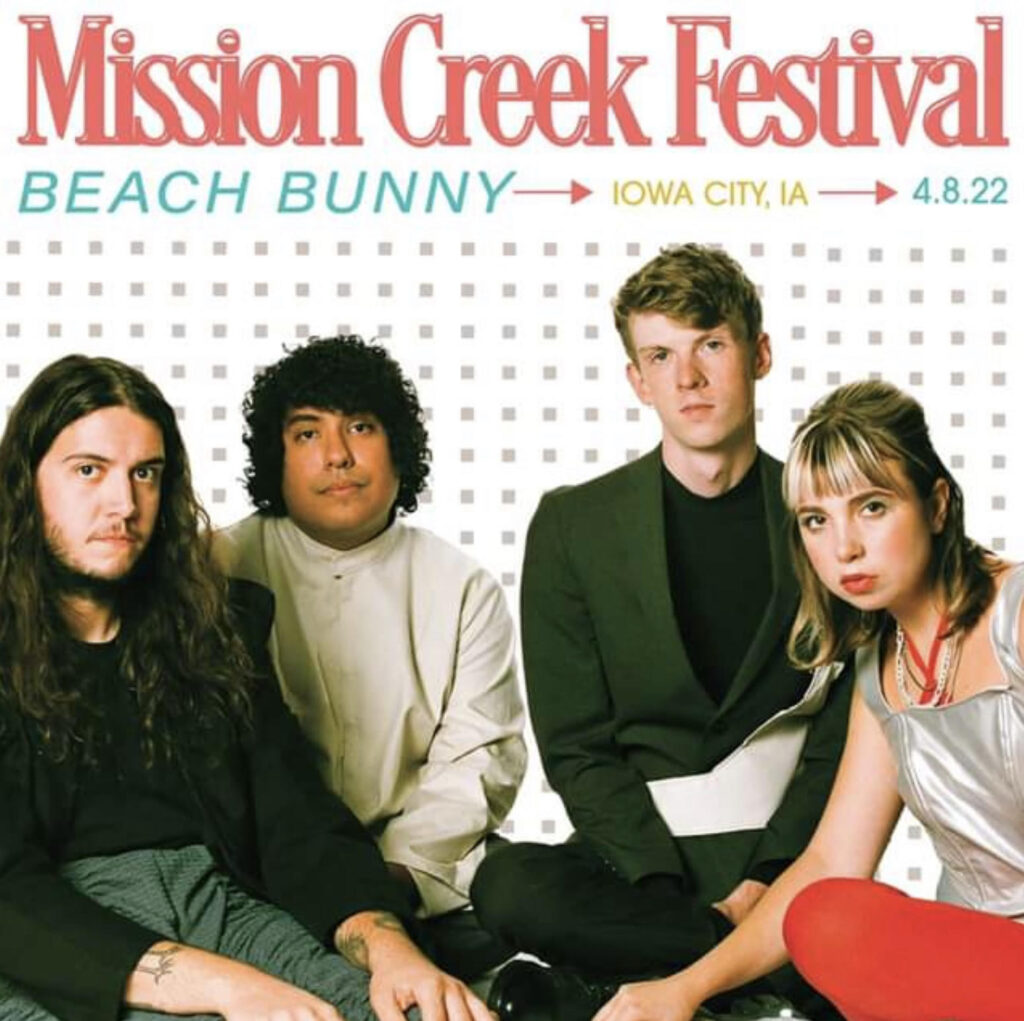 Beach Bunny poses infront of a background that says "Mission Creek Festival, Beach Bunny"
