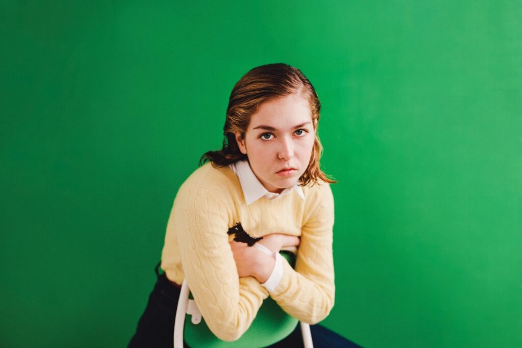 Snail Mail's Lindsay Jones poses over a lush green background
