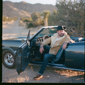 Nate Currin sitting in a car with the door open.